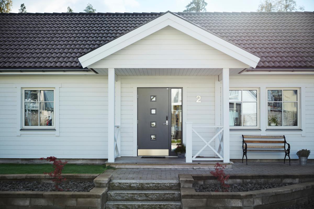 Start 13 Fasad och hus med en ny grå dörr.